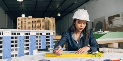 african-american-woman-safety-helmet-working-near-model-building